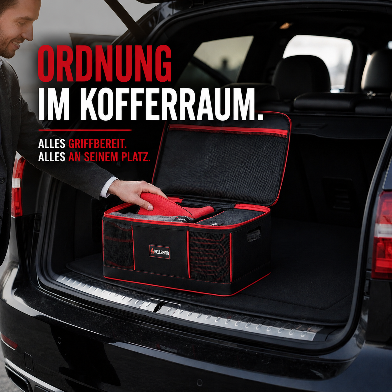 HELLBURN Aufbewahrungsbox für Mikrofasertücher im geöffneten Kofferraum eines Fahrzeugs, gefüllt mit roten und grauen Autopflege-Tüchern für Lack, Felgen und Innenraum. Premium-Organizer in Schwarz-Rot mit Text „Ordnung im Kofferraum“ für strukturierte Fahrzeugpflege und schnellen Zugriff auf Pflegezubehör.